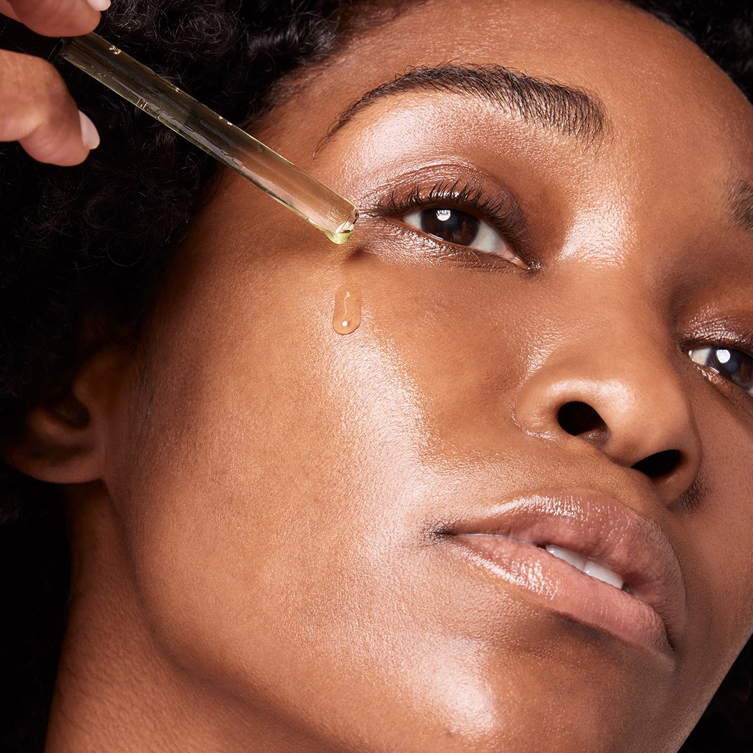 Close-up of a person applying a dropper of liquid to their eye.